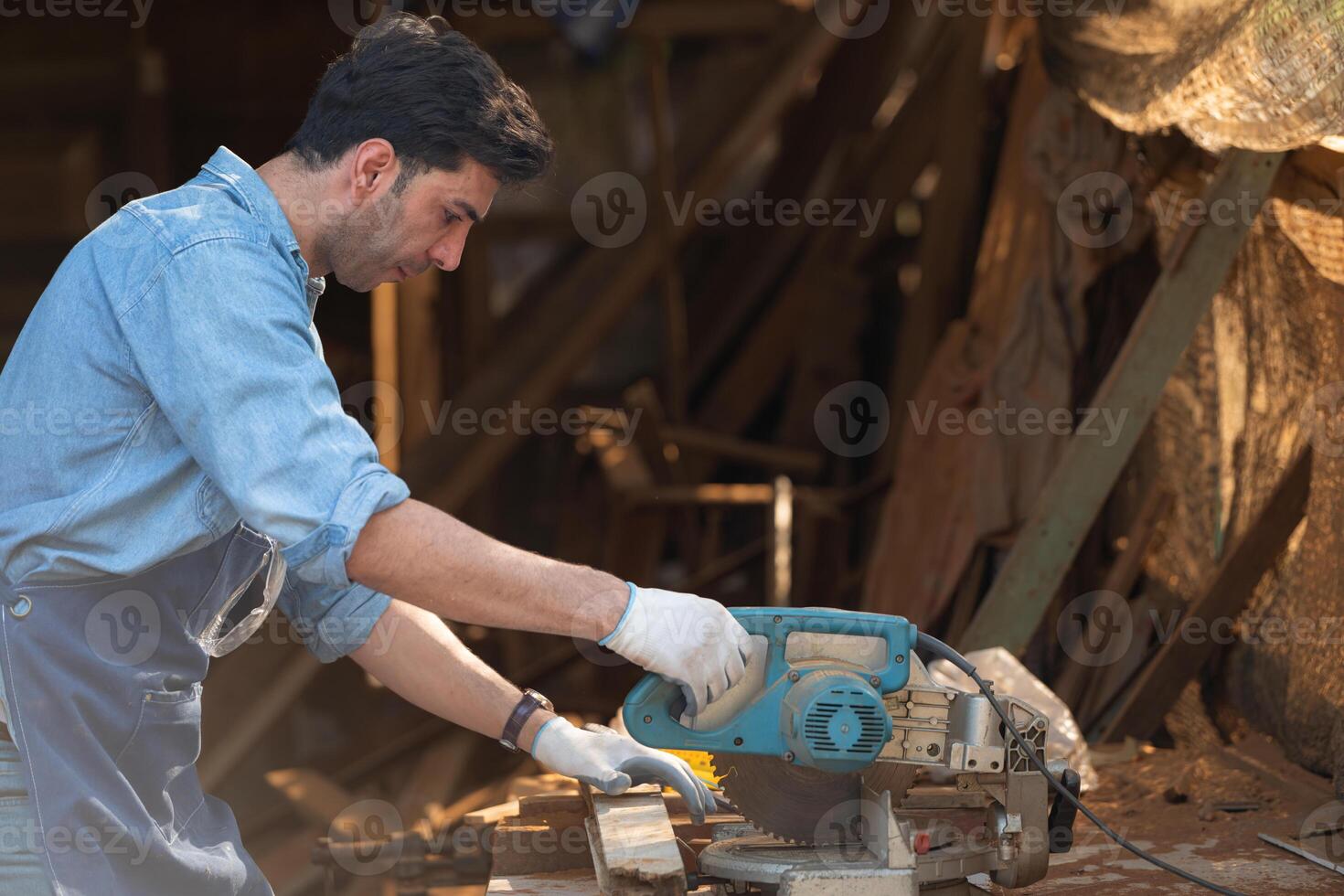 retrato de un artesano trabajando con un circular Sierra a un madera taller foto