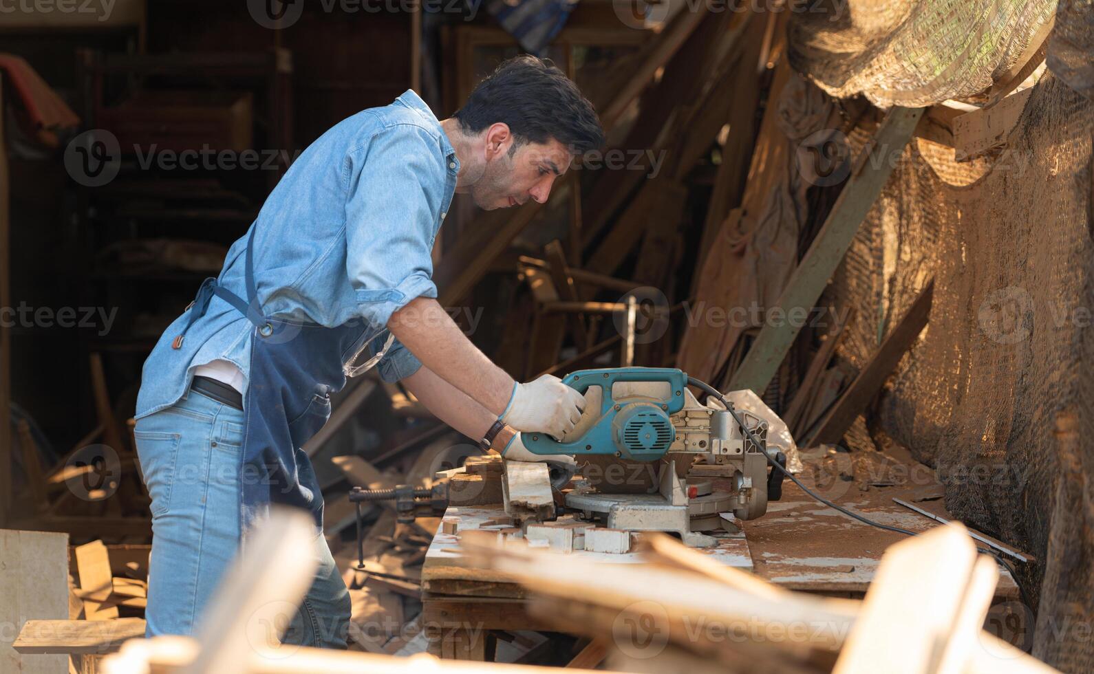 retrato de un artesano trabajando con un circular Sierra a un madera taller foto