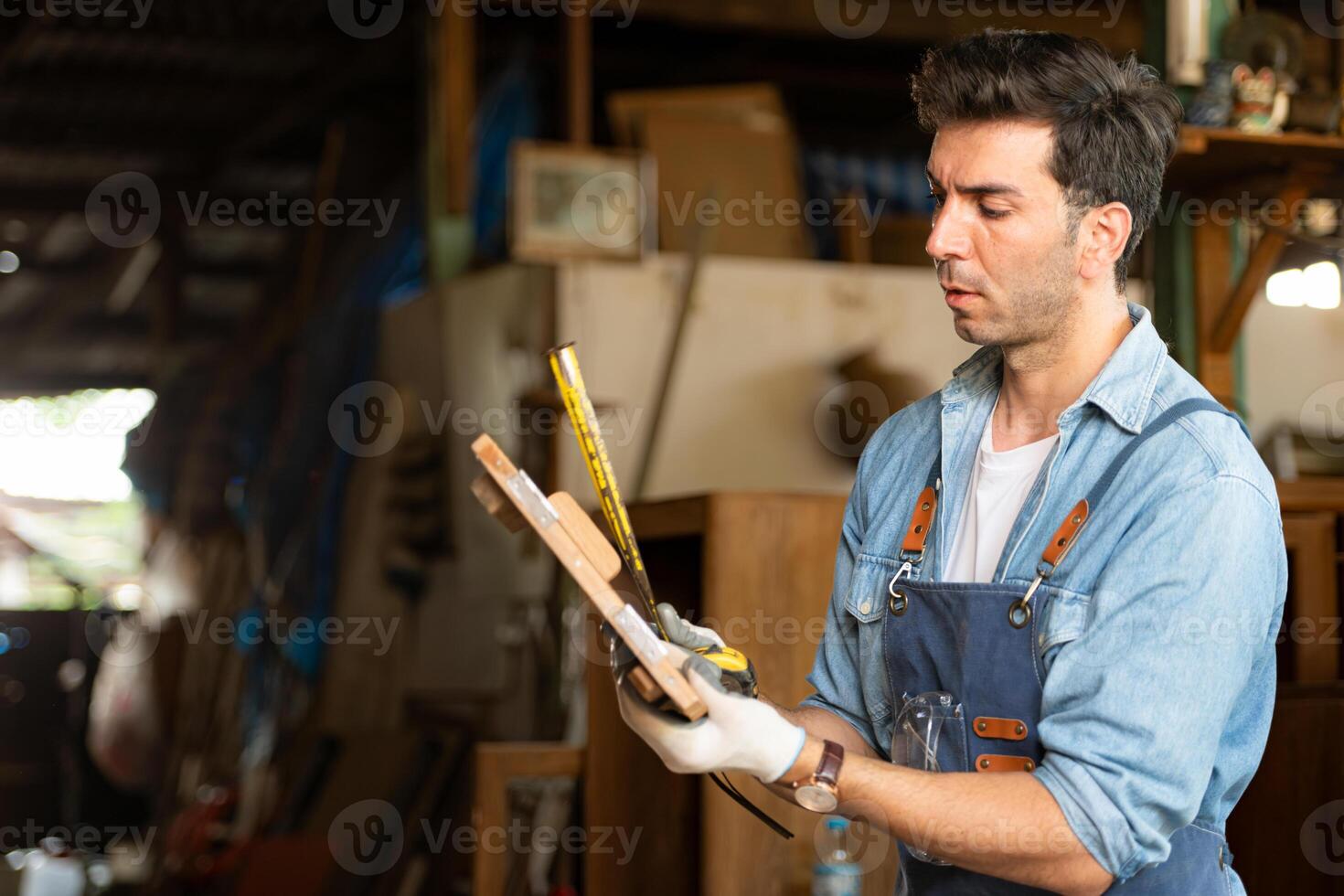 Carpenter working at his carpentry shop. Eyesight is utilized to ensure accuracy. photo