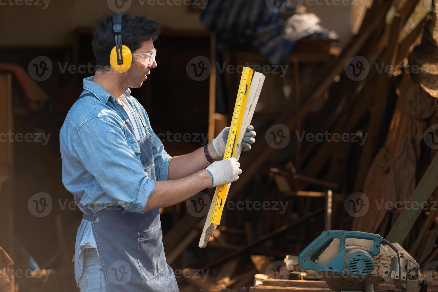 Portrait of a carpenter holding a spirit level in his workshop. photo