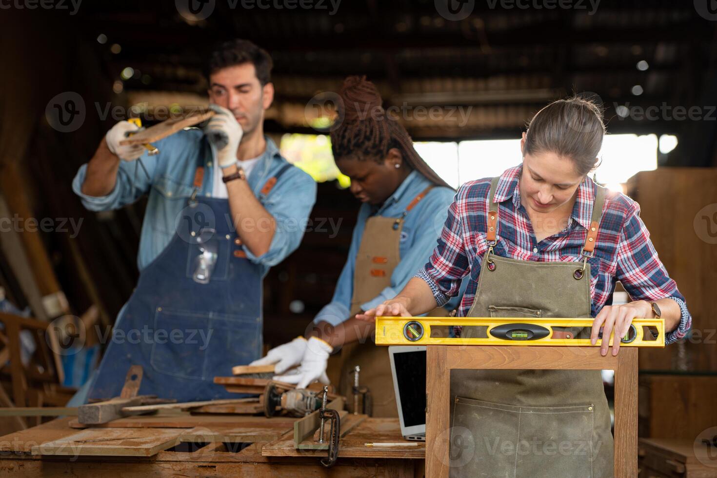 Portrait of carpenter female worker standing in front of colleague in workshop, Eyesight is utilized to ensure accuracy. photo