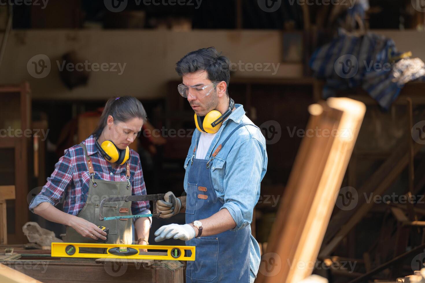 Carpenter and his assistant working together in a carpentry workshop photo