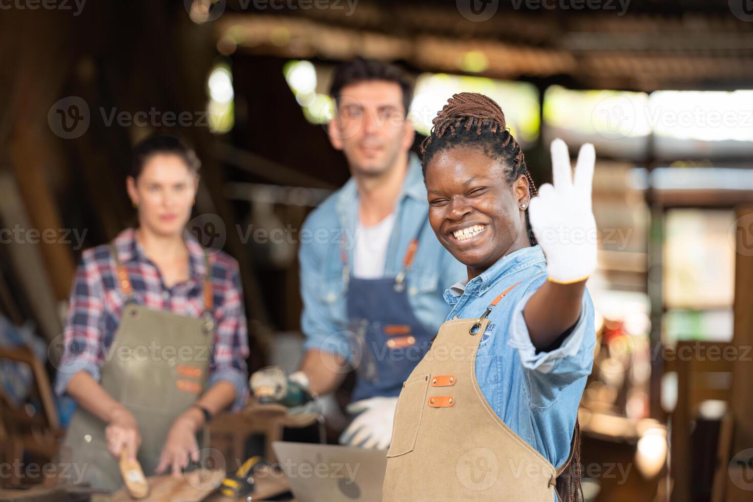 retrato de carpintero hembra trabajador en pie en frente de colega en taller foto