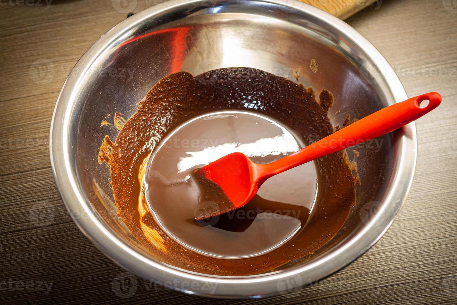 mujer Cocinando sabroso Derretido chocolate en mesa en cocina. foto