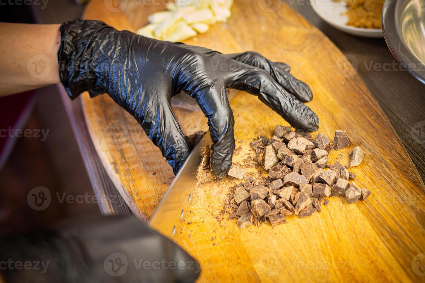 Woman cooking tasty melted chocolate on table in kitchen. photo