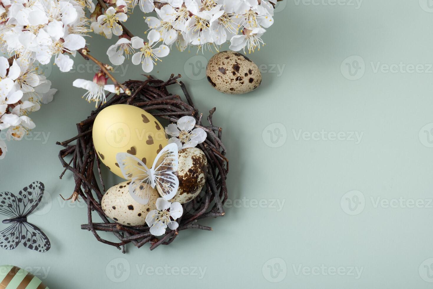 Easter eggs in a nest with flowers and butterflies with a flourish on a pastel green background photo