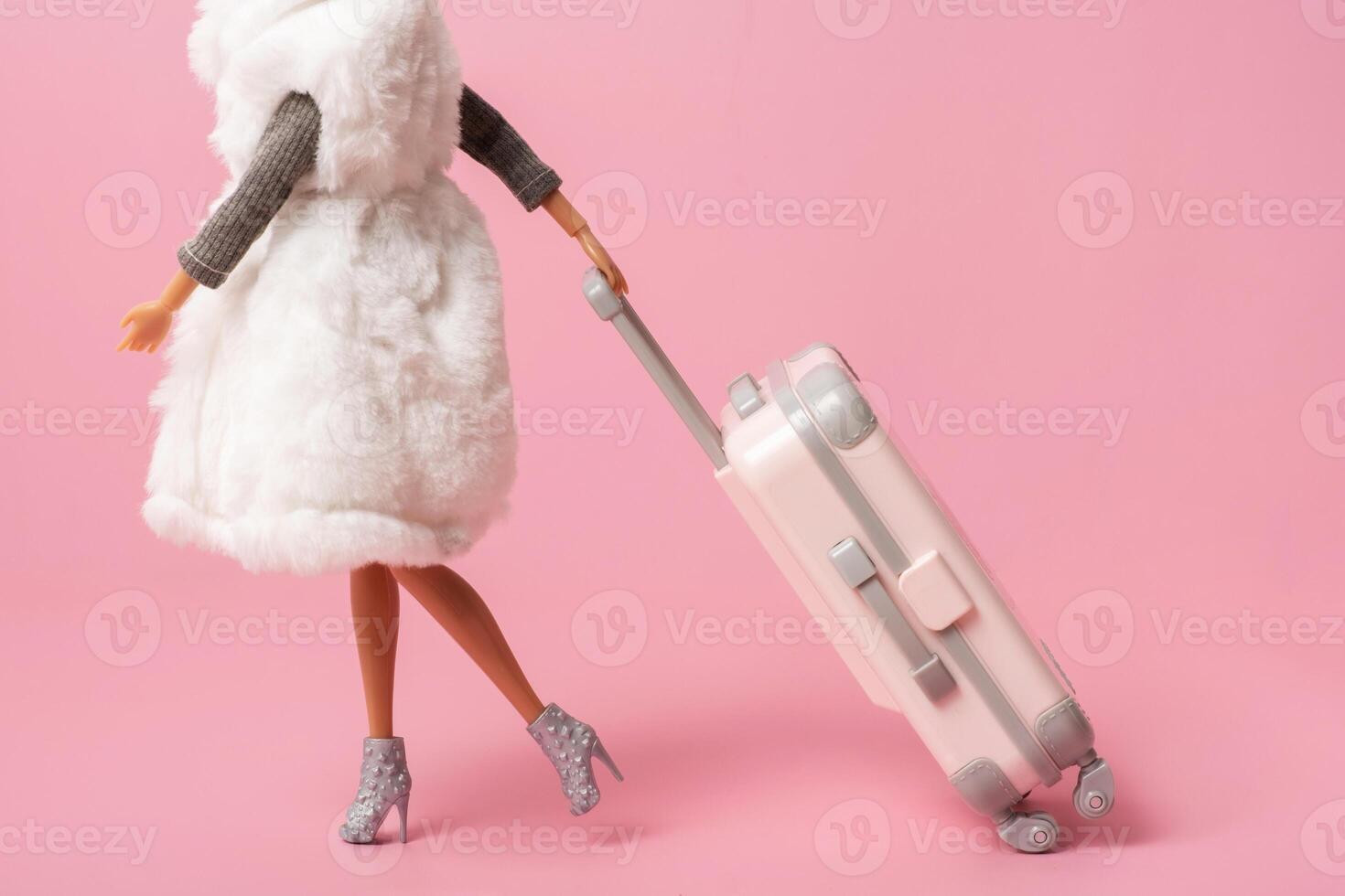 A doll with a suitcase on wheels rushes to the plane. Travel, vacation creative minimalistic concept photo