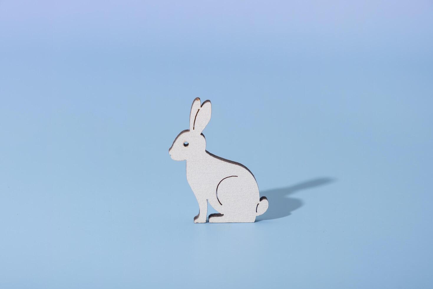 Wooden rabbit symbol for Easter on a blue background photo