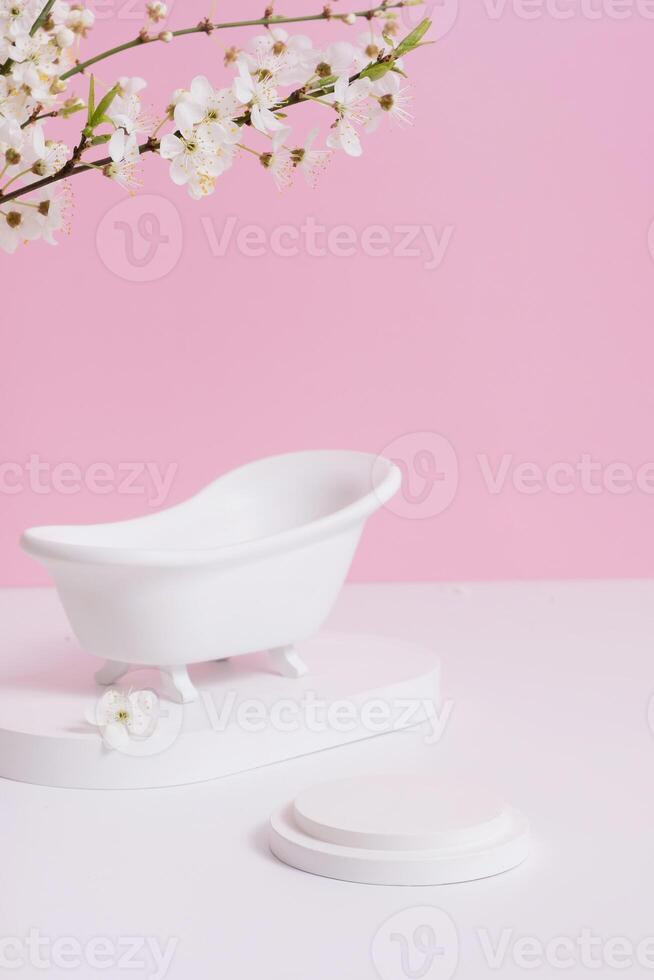 Empty white podium or pedestal with decorative bath and spring bloom. Mock up for cosmetic products photo