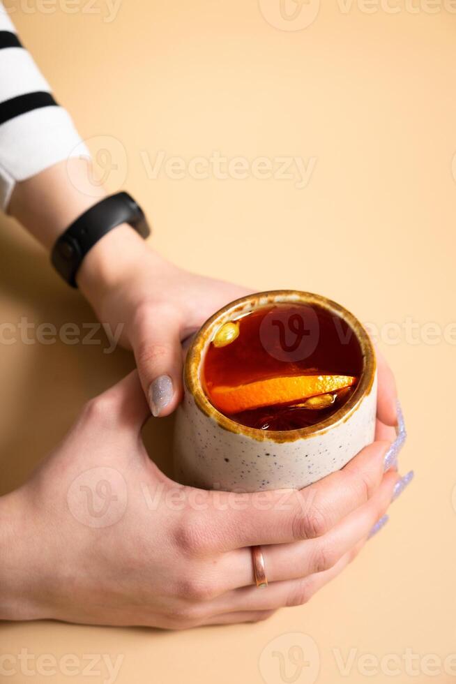 Cup with mulled wine in female hands, angle view. photo