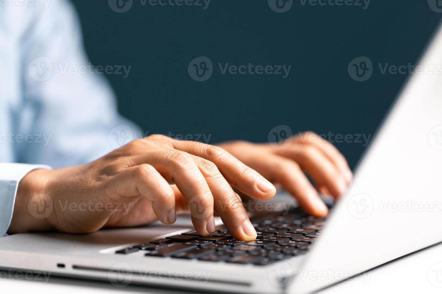 Businesswoman hand typing on laptop computer while working in white modern office room. photo