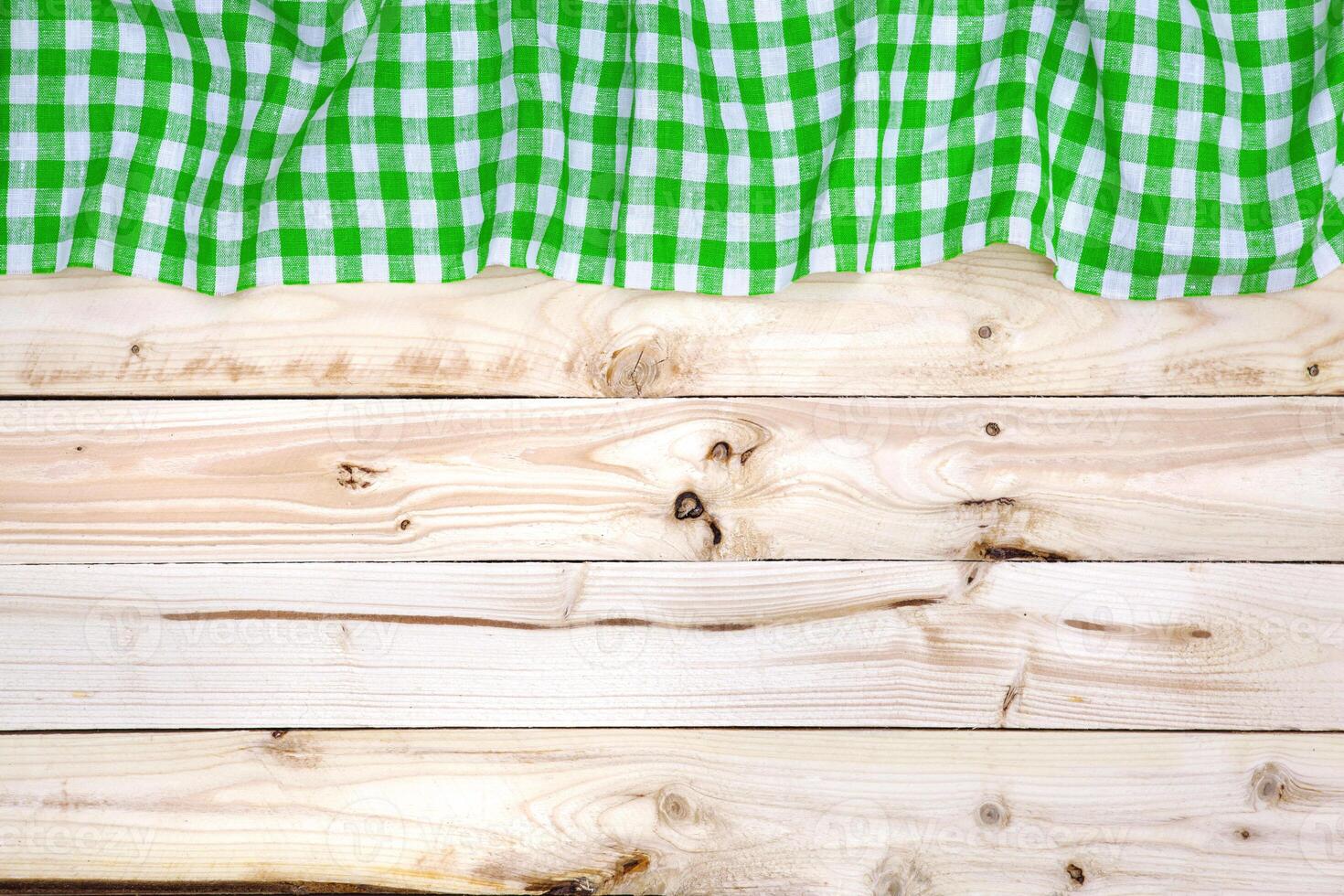 Green tablecloth on wooden table, top view photo