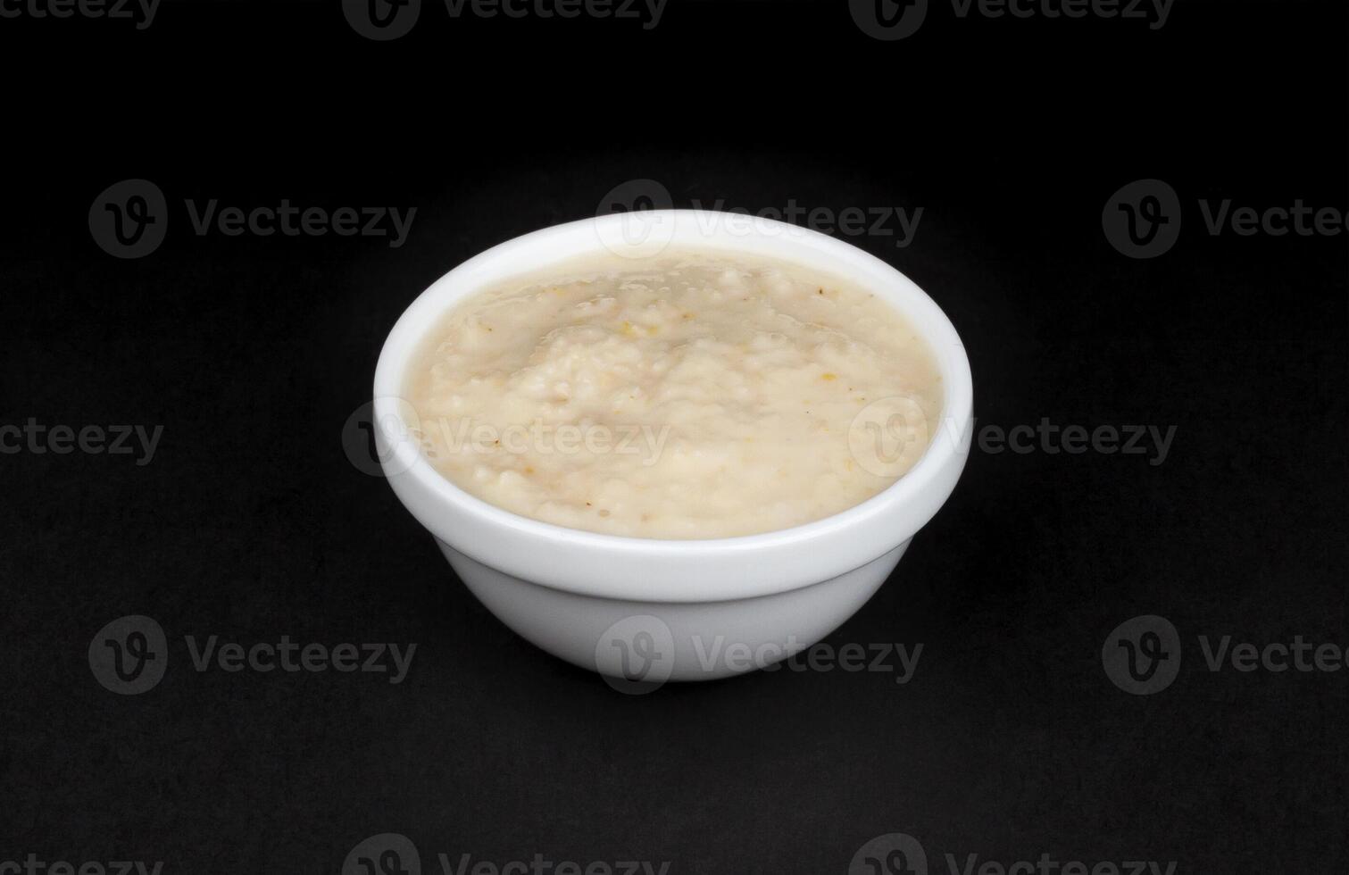 Horseradish sauce in bowl isolated on black background photo