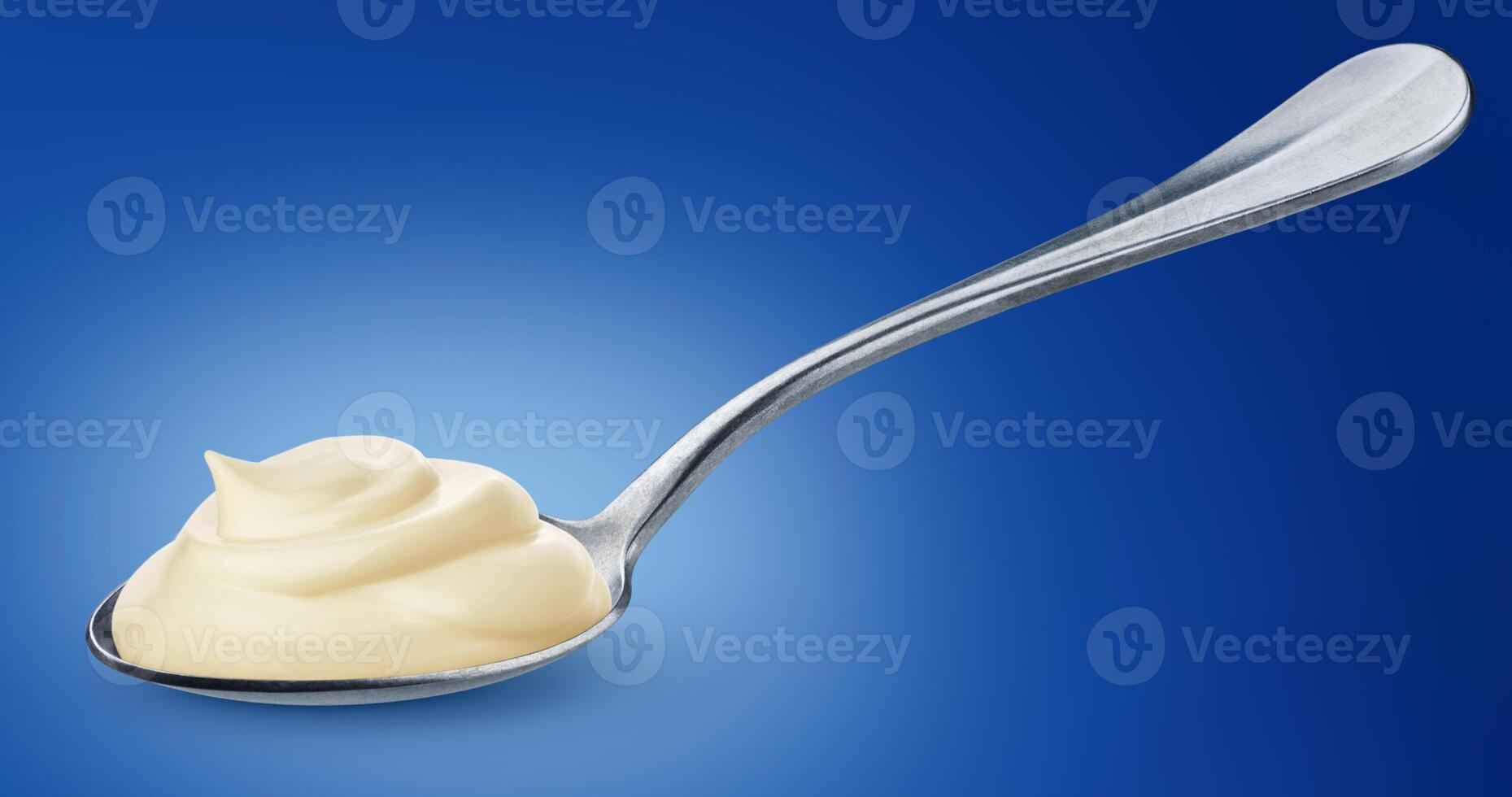 Sour cream in spoon isolated on blue background photo