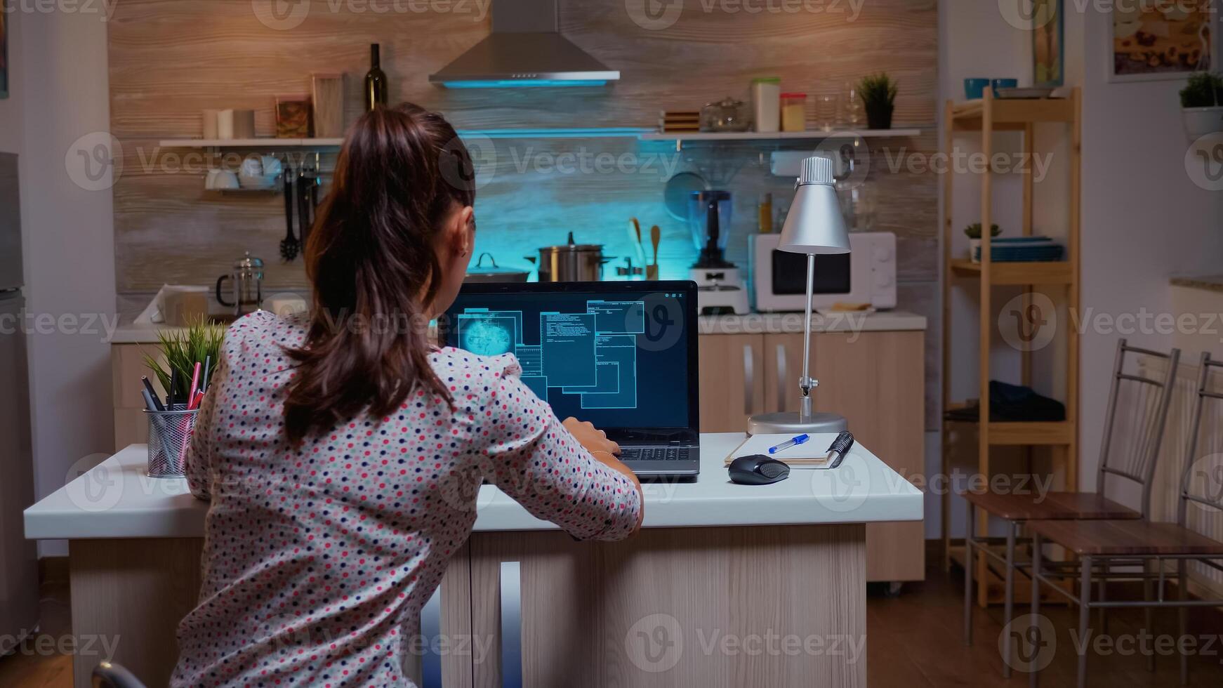 Woman scrolling programming security hacking code data late at night on laptop. Programmer writing a dangerous malware for cyber attacks using performance device during midnight. photo