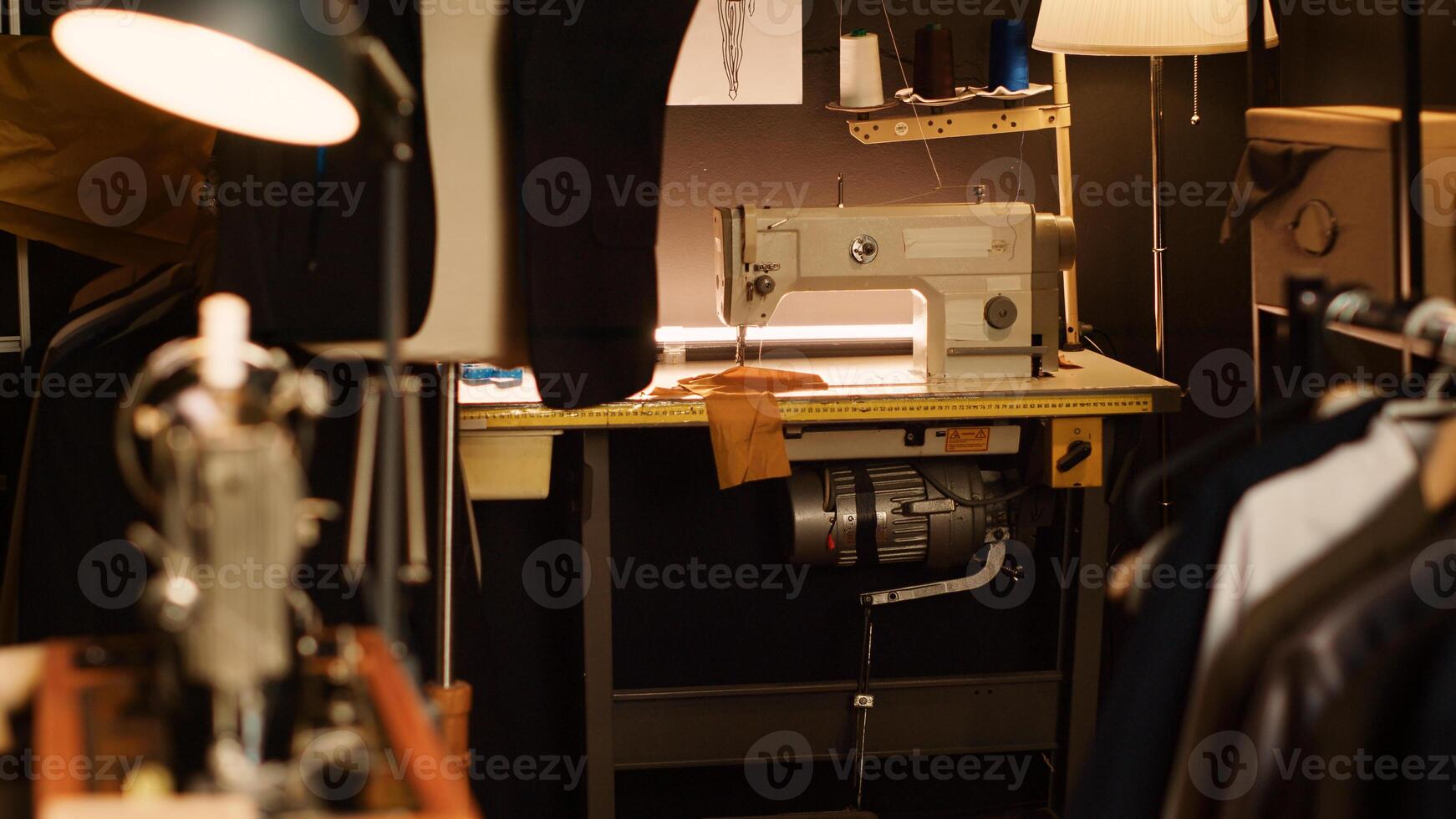 Industrial sewing machine workstation and fashion atelier, tailoring and needlework equipment used to create custom made clothes. Small business in textile industry, clothing atelier. photo