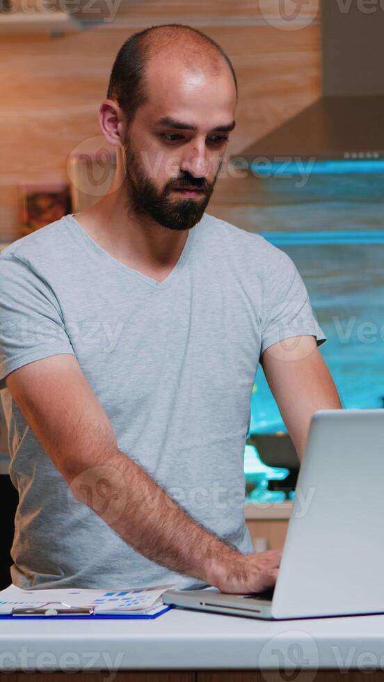 Overwork remote manager tired late hour job program looking astonished at watch. Busy focused employee using modern technology network wireless doing overtime for job reading writing, searching photo
