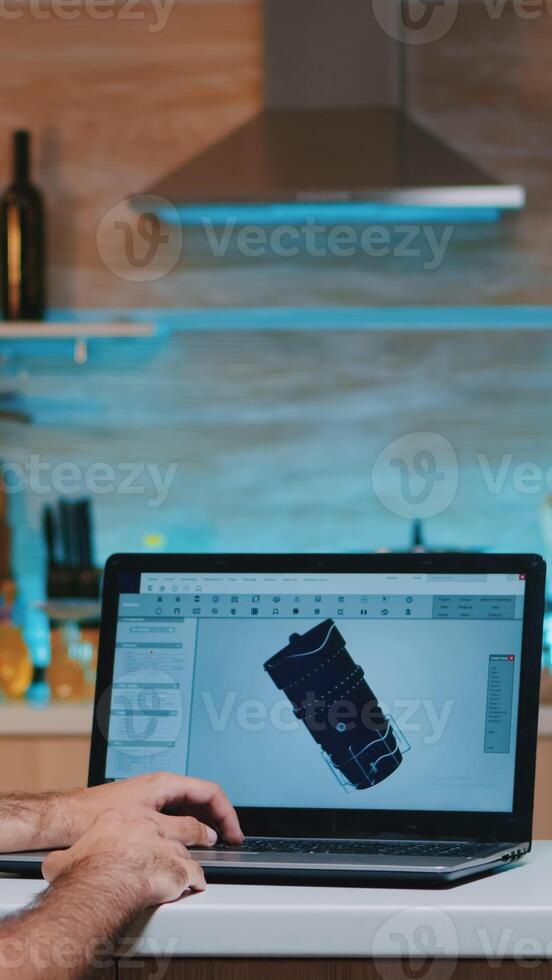 Remote man architect working from home at laptop on modern cad program overtime wearing headset. Industrial employee studying prototype idea on computer showing cad software on device display photo