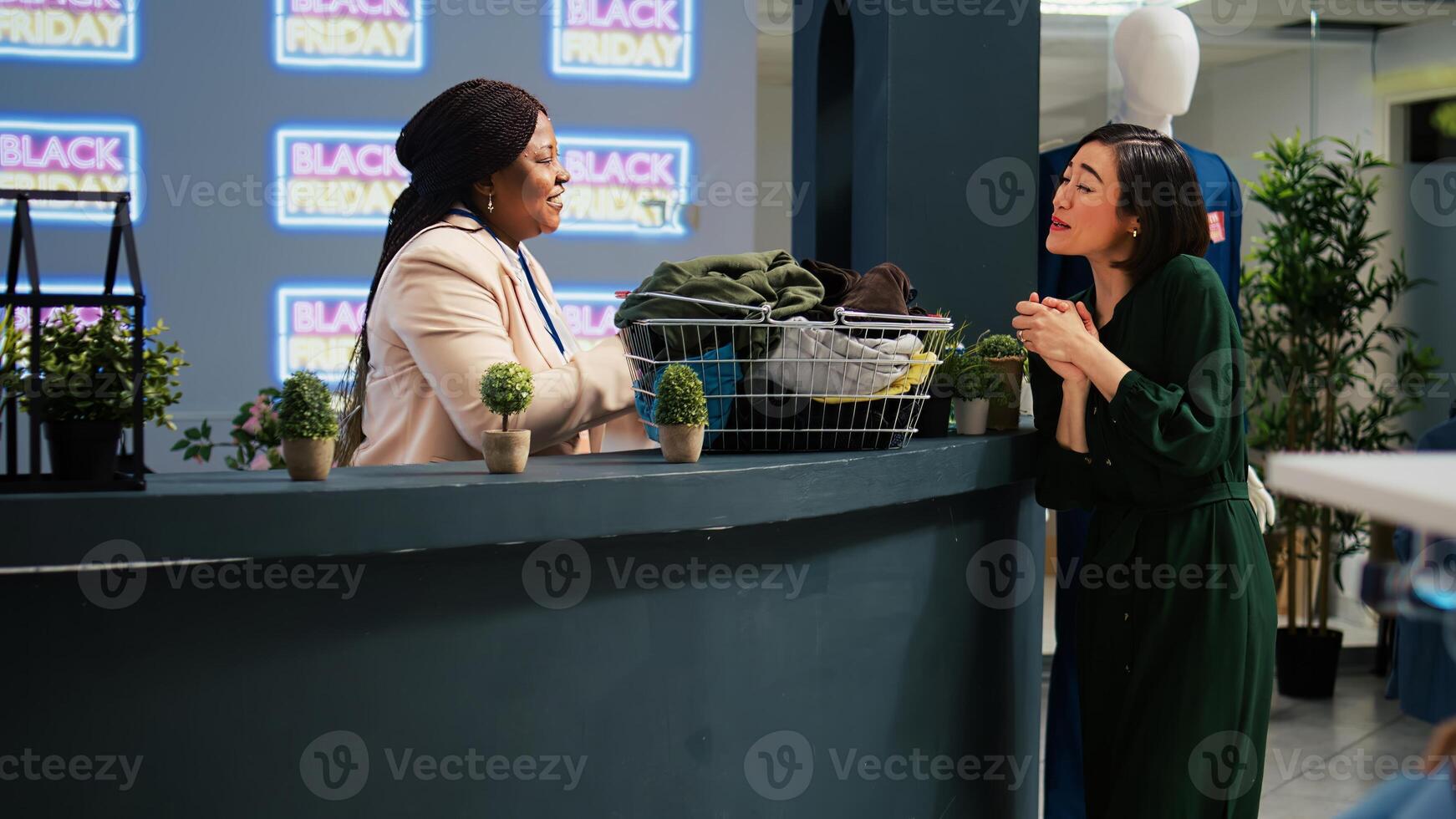 Satisfied woman customer at checkout counter buying new fashion items on discount during black friday sales event. Shopper grabbing clothes from racks and shelves in shopping mall. photo