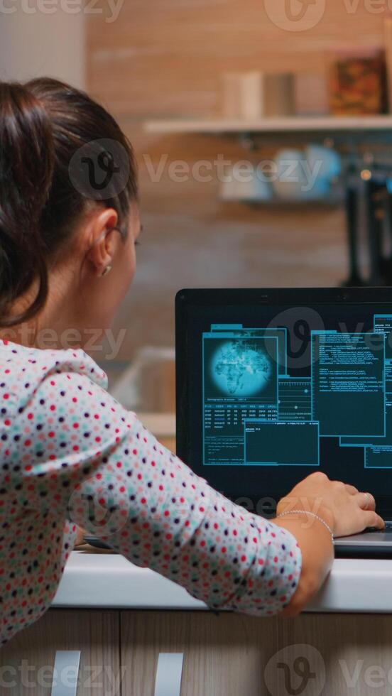 Woman hacker coding html and programming on screen laptop working from home in midnight. Programmer writing a dangerous malware for cyber attacks using performance device during midnight. photo