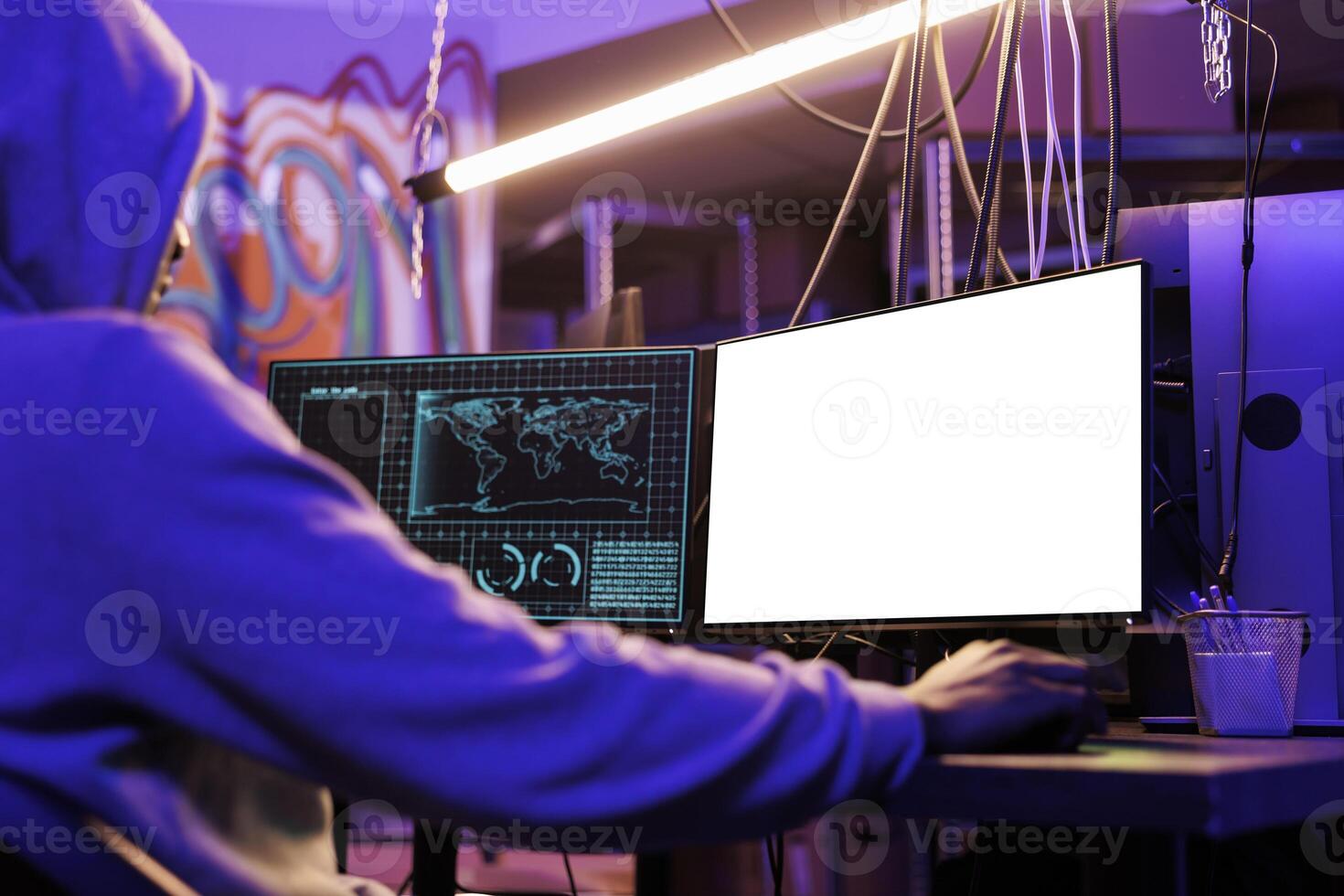 Man hacking online server on computer with empty screen mock up. Hacker in hood programming malicious software and cracking password while looking at white blank monitor at night photo