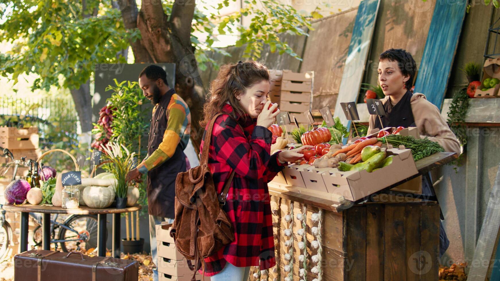 Small business owner selling fresh organic products from stand, talking to customer about healthy eating and local natural veggies. Female person asking market stall holder about bio products. photo