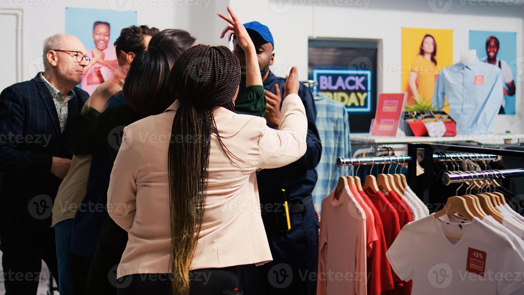 Diverse customers waiting in line for promotions and special offers, standing behind red tape at clothing store entrance. Shoppers pushing retail store employee, obsessed crowd. photo