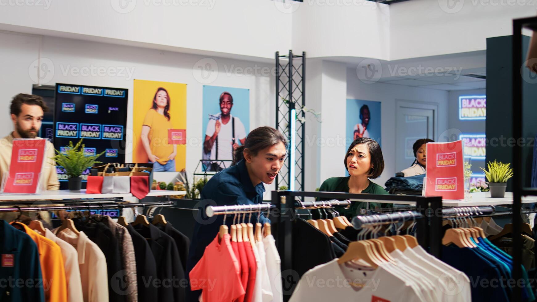 Anxious clients grab discounted clothes, rushing to catch big sales promotions on black friday. Obsessed people taking fashion items at outlet store, shopaholic buyers hunting for bargains. photo