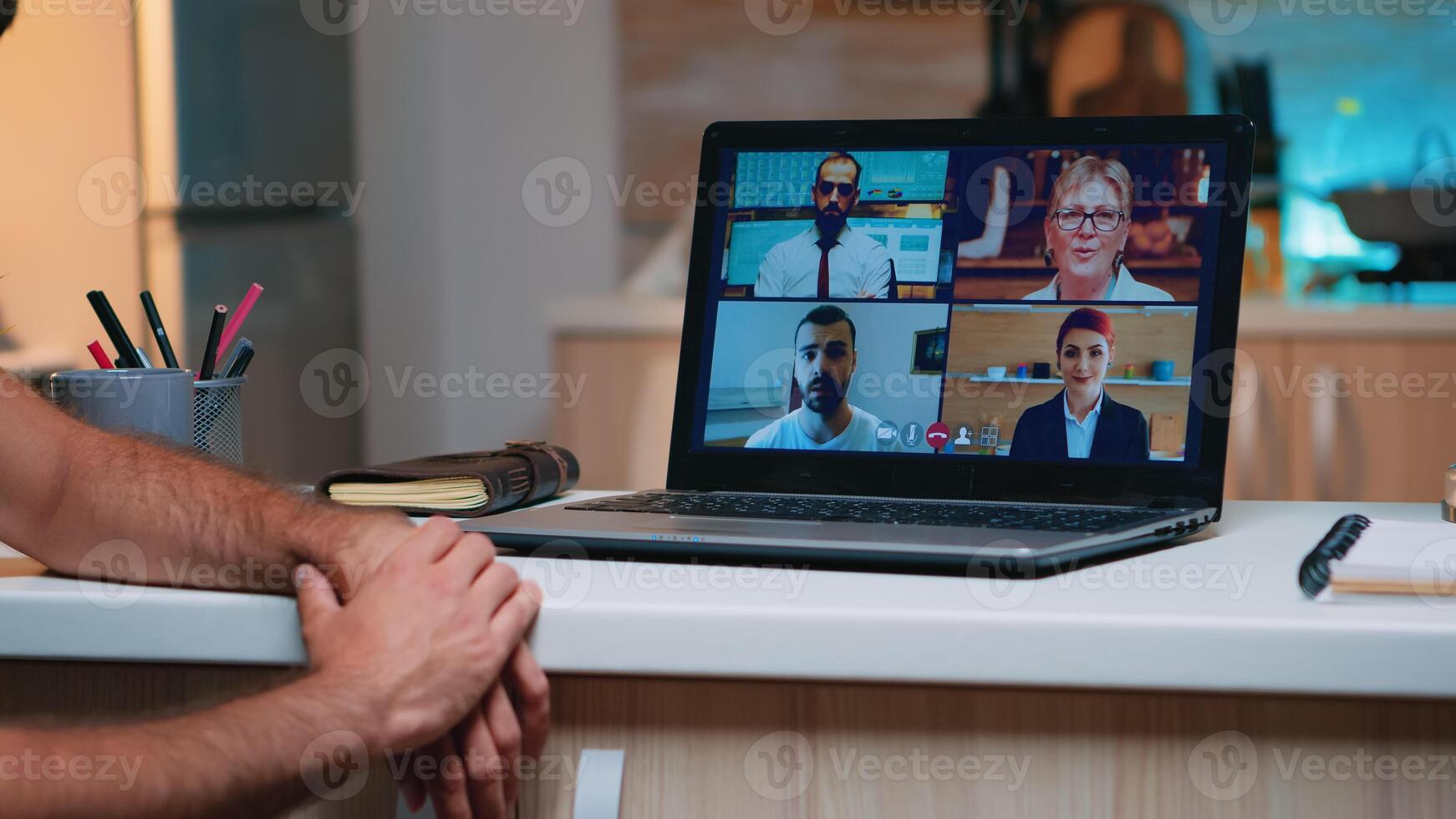 remoto empleado teniendo vídeo conferencia trabajando desde hogar sentado en el cocina tarde noche. persona de libre dedicación utilizando moderno tecnología red inalámbrico hablando en virtual reunión a medianoche haciendo tiempo extraordinario foto