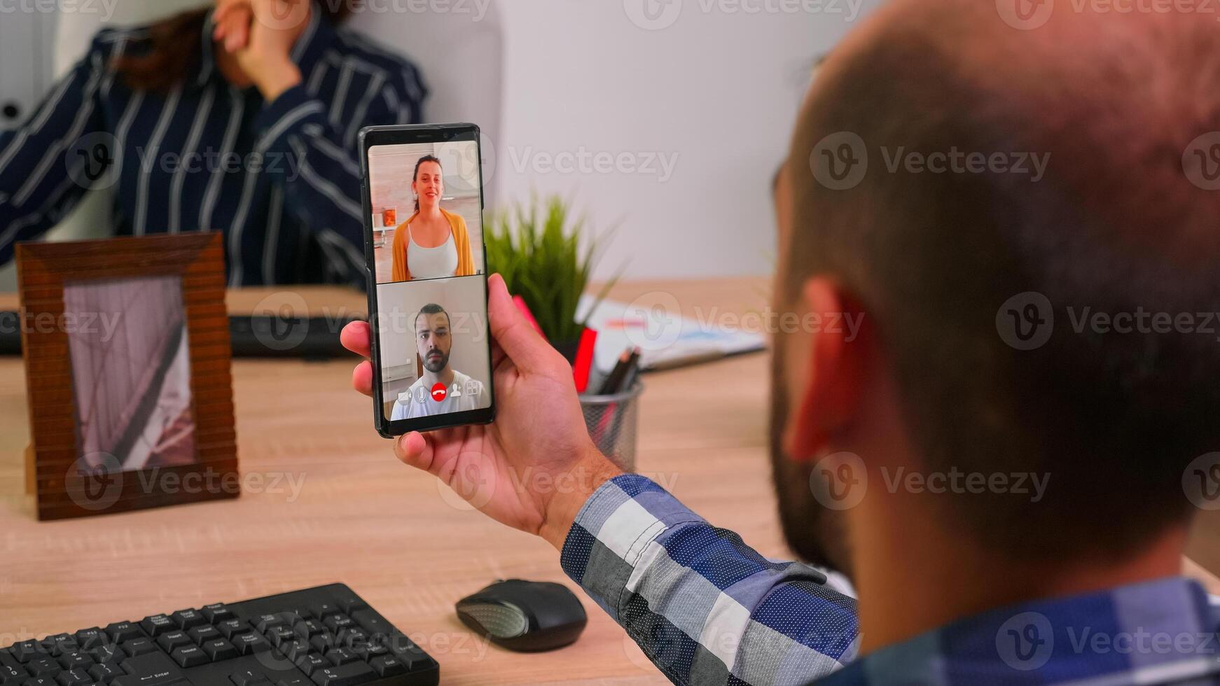 Financial businessman having a videomeeting talking with company manager and executive administrator sitting on desk in corporate building office. Entrepreneur using modern technology. photo