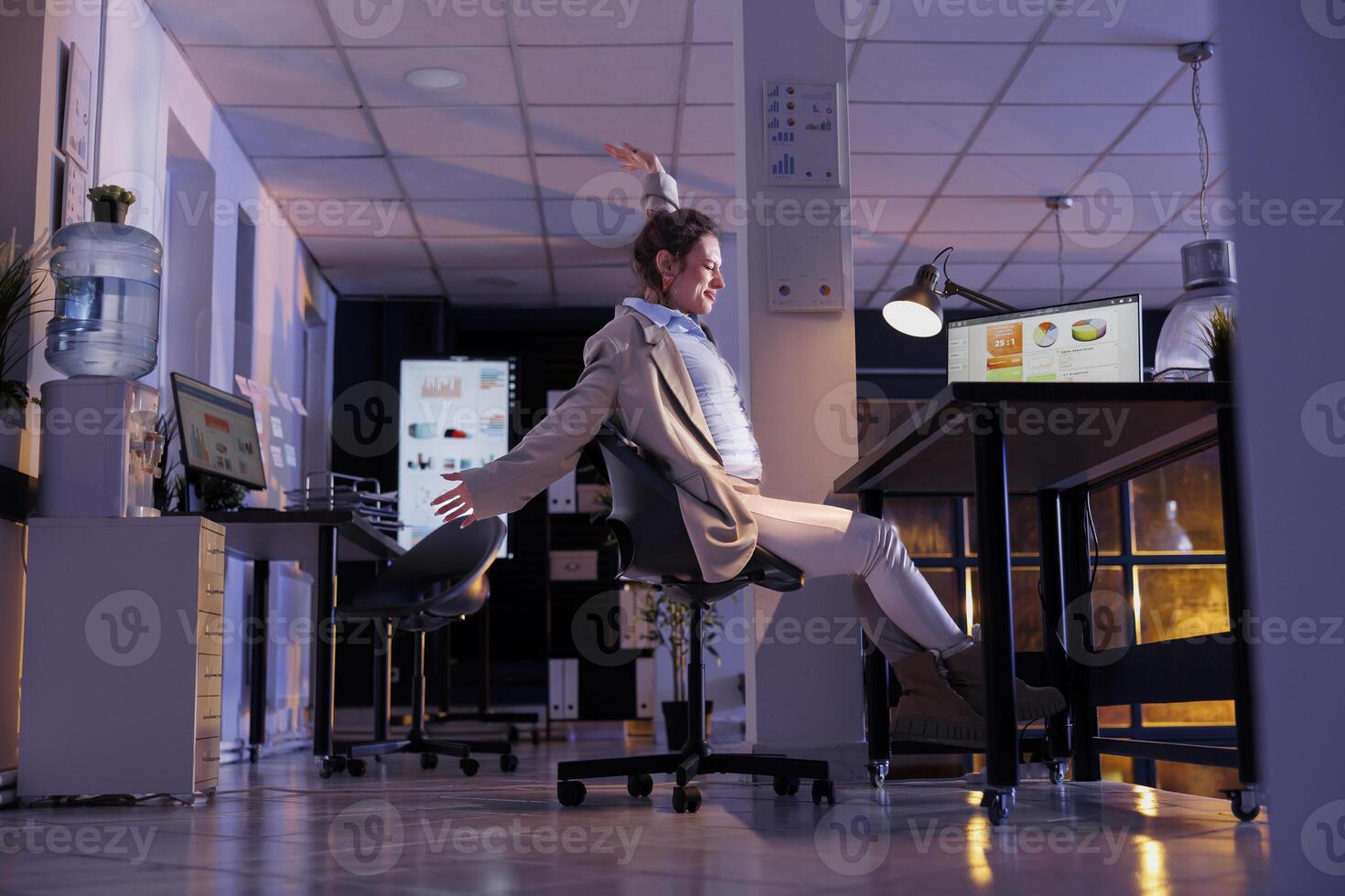 Entrepreneur doing relaxation exercises in startup office after working overhours at company strategy. Tired executive manager analyzing marketing graphs report on computer. Corporate job concept photo