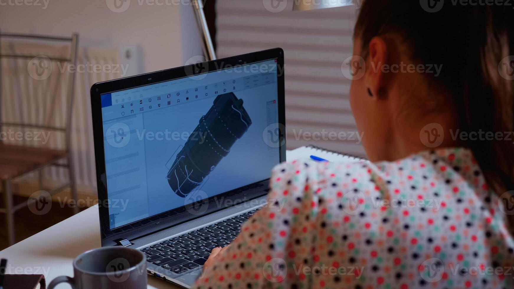 Engineer working late at night on a 3D model of industrial turbine from home. Remote freelancer studying prototype idea on personal computer showing cad software on device display photo