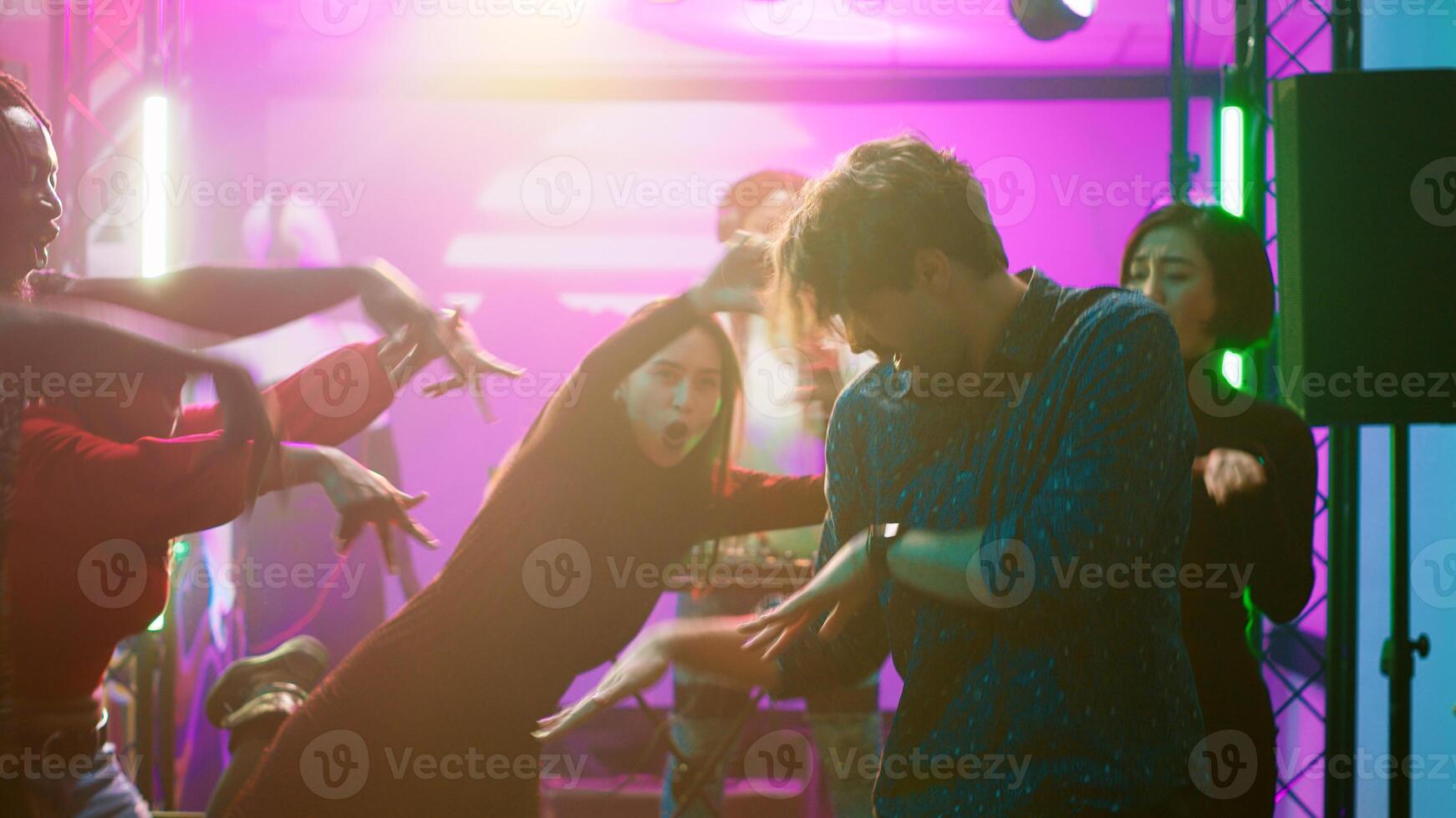 People starting fun dance battle at club, having fun together at party with electronic music. Talented confident persons creating breakdance battle at nightclub event. Tripod shot. photo