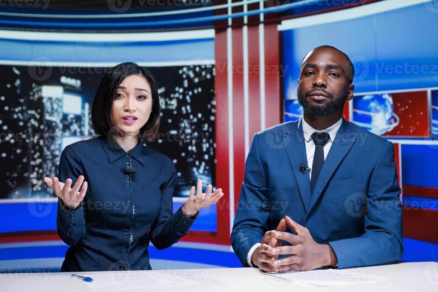 Talk show hosts reading breaking news headlines live on television broadcast, working together to provide relevant content for tv program. Diverse team of reporters in newsroom. photo