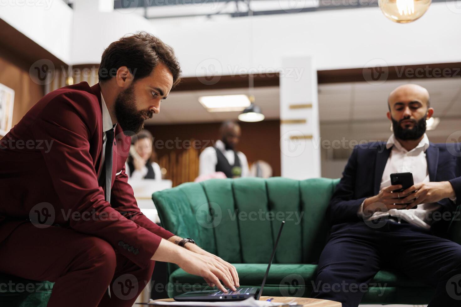 Employee review information in hotel lobby, sorting files to present at international meeting with executive board members. Professional in suit travelling for business trip, lounge area. photo