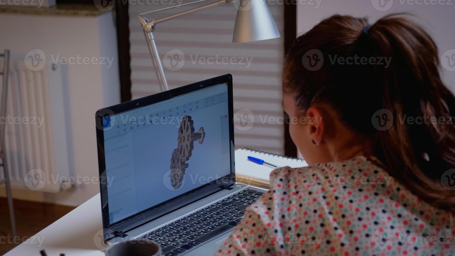 Freelancer working remotely on cad software using laptop innovating an efficient eco-friendly motor prototype. Industrial female engineer studying new idea on personal computer looking on device display photo