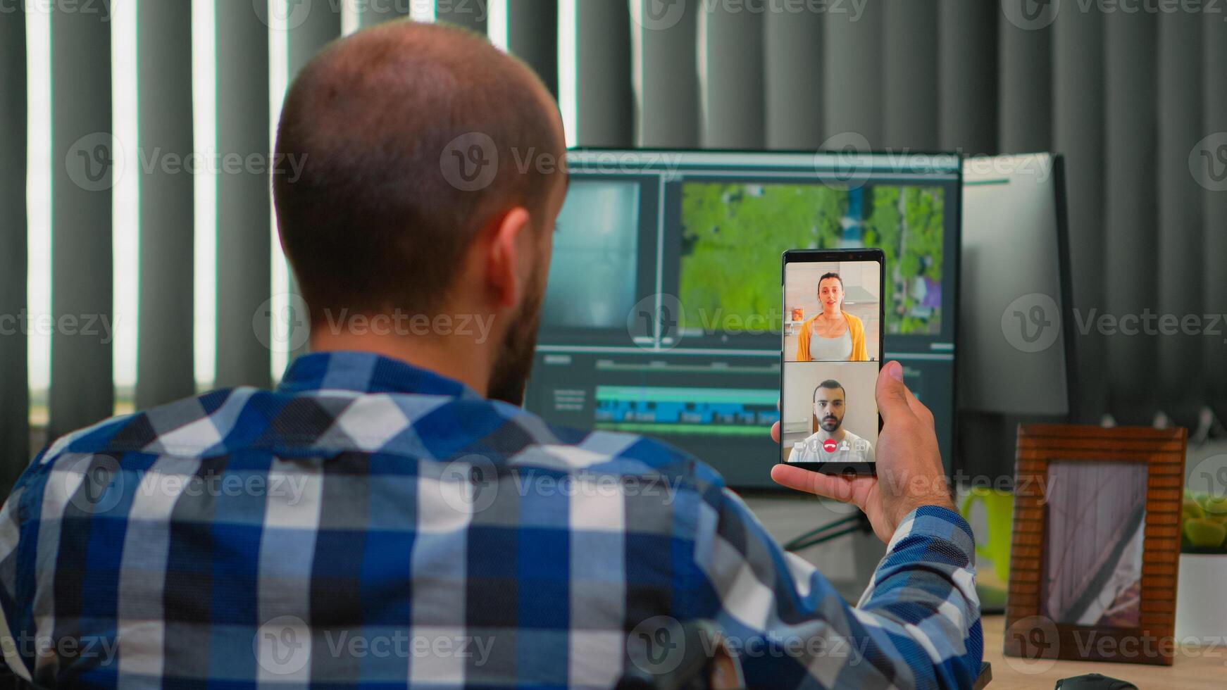 Freelancer video editor with disability in wheelchair having videocall while editing postproduction an project creating content in modern company office. Videographer working from photo studio