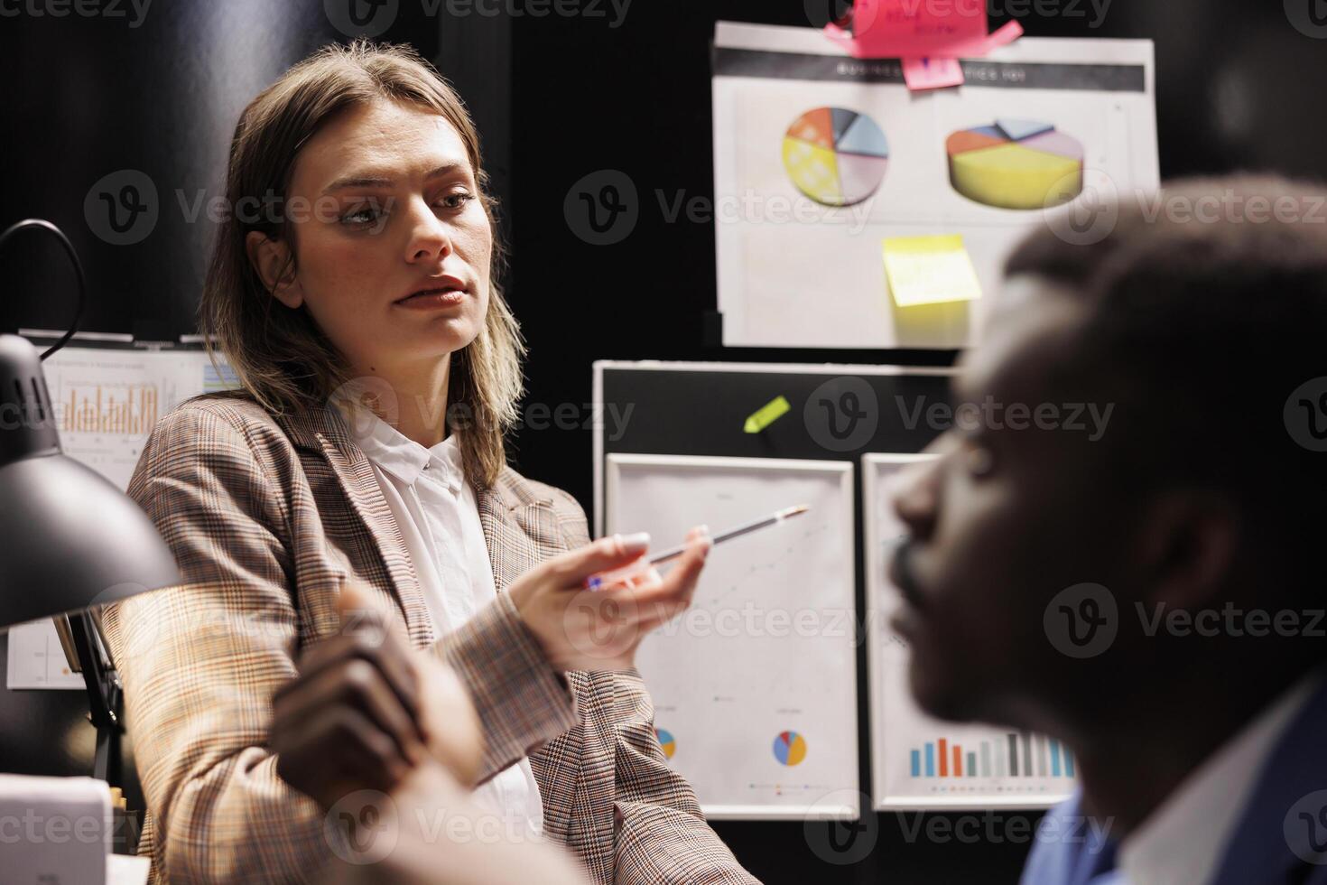 Bookkeepers working overhours at accountancy report, analyzing administrative documents. Diverse businesspeople checking accountancy report, discussing management research in storage room photo