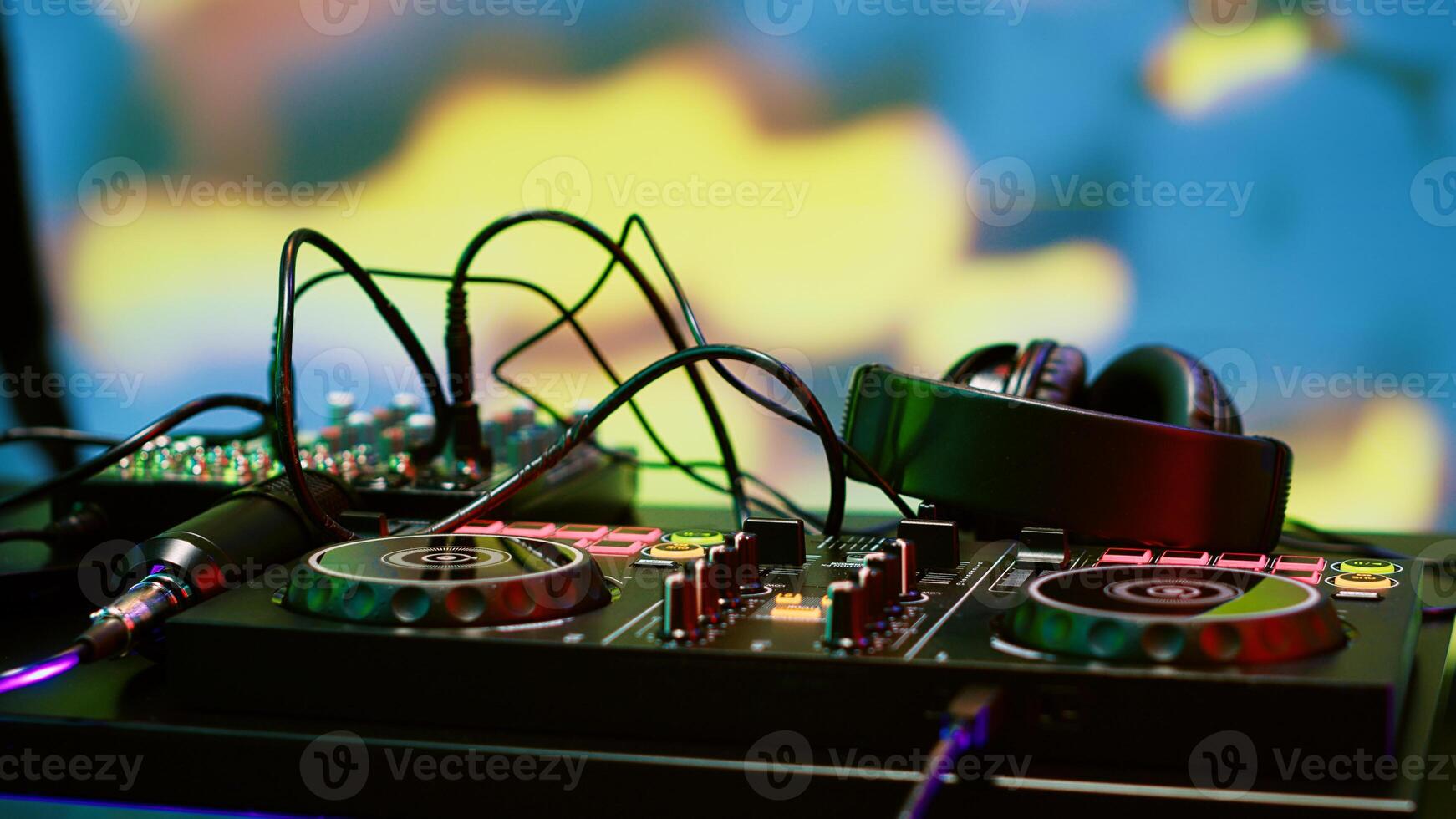 Mixing DJ station for live music on stage at discotheque, funky underground event at nightclub. Empty club and dance floor with audio panel equipment, disco party with spotlights. Close up. photo