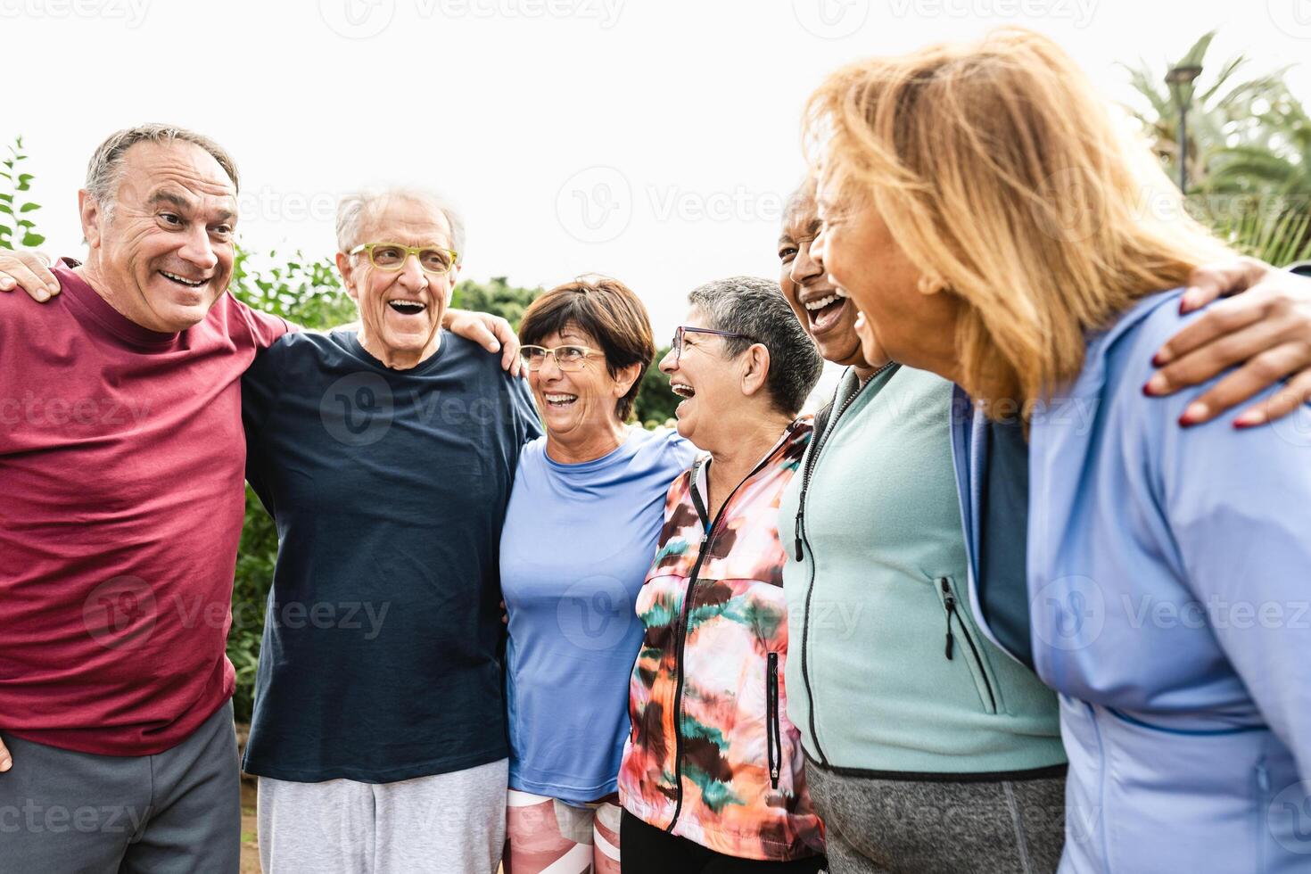 grupo de diverso mayor amigos teniendo divertido después rutina de ejercicio sesión a parque foto