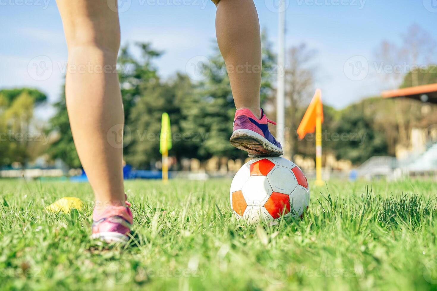 Young female soccer player traning with ball in the stadium - Sporty woman making exercises on the train field - Concept of sportive people lifestyle photo