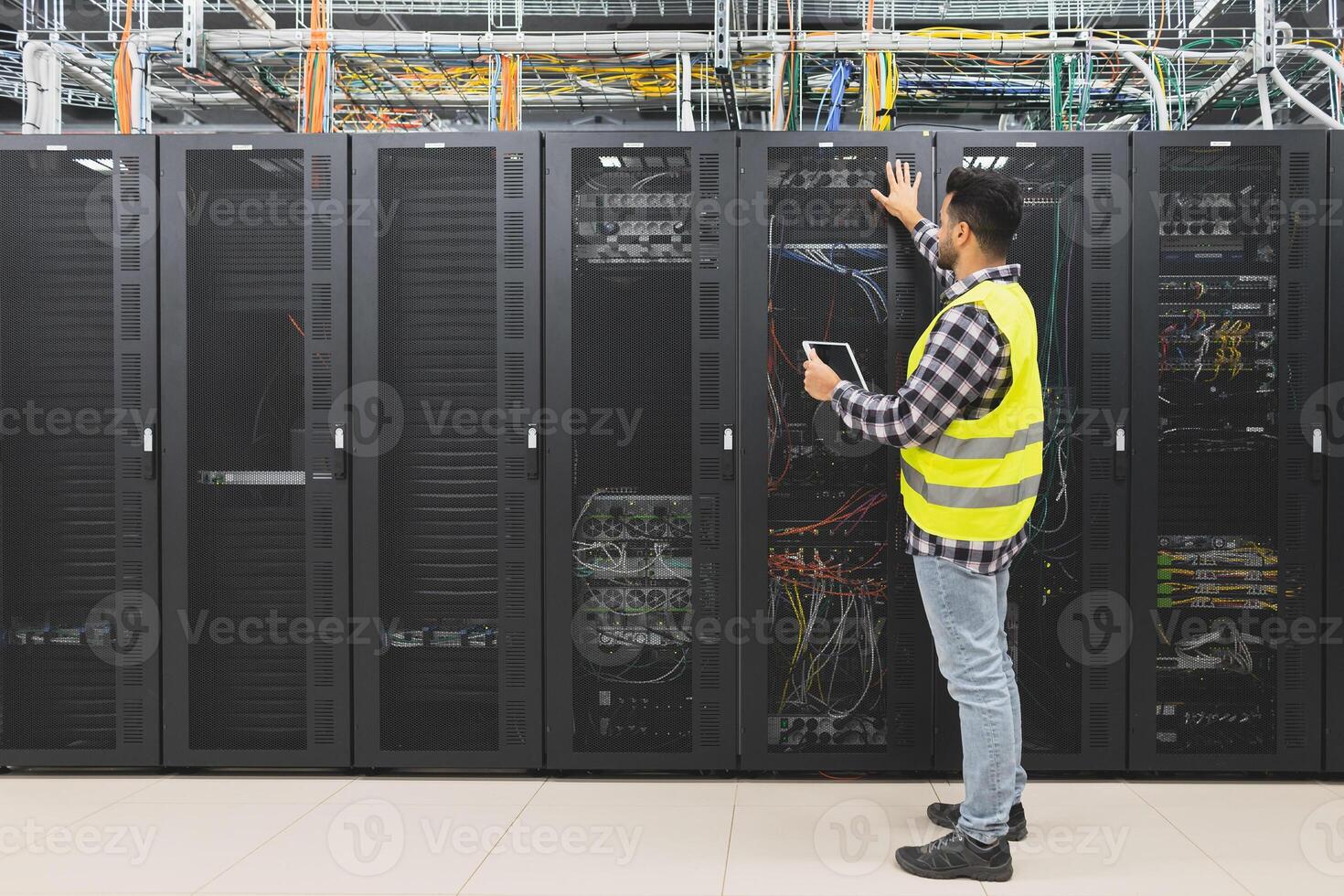 Male informatic engineer working inside server room database photo