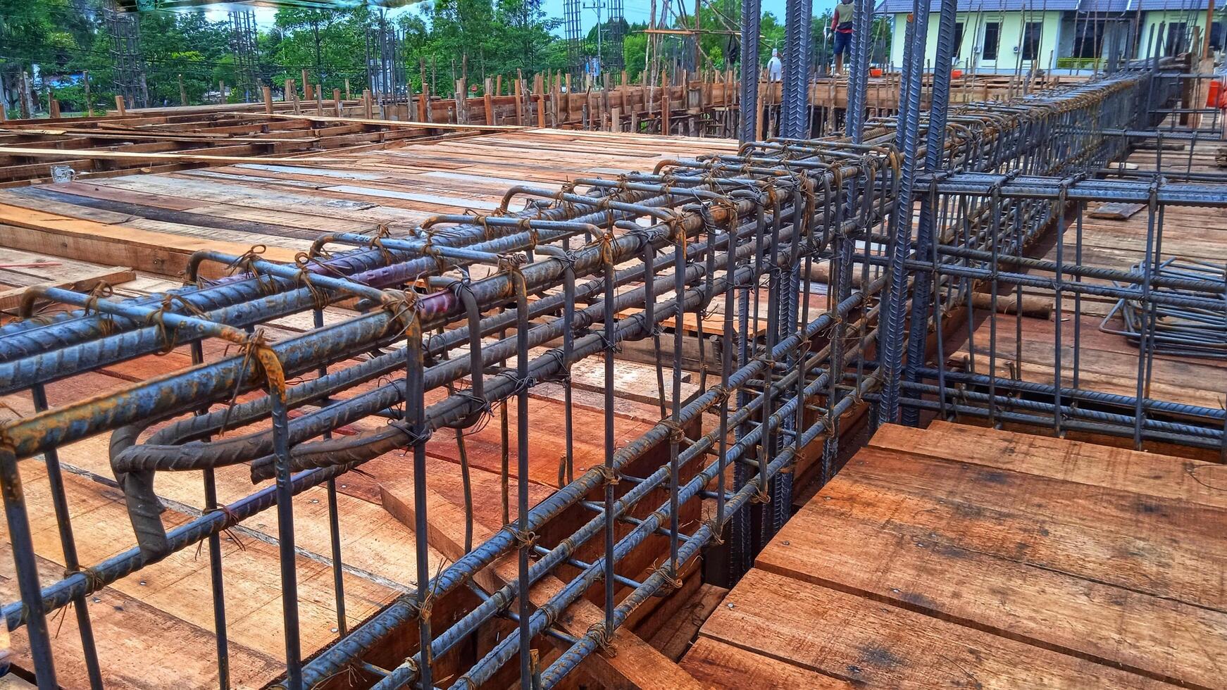 Construction worker stringing reinforcing steel rods at construction site. photo