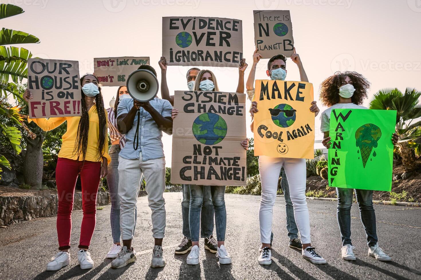 grupo de activistas protestando para clima cambio durante covid19 - multirracial personas luchando en la carretera participación pancartas en ambientes desastres - global calentamiento concepto foto