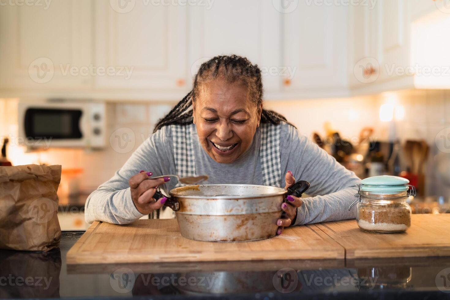 Happy senior African woman preparing a homemade dessert photo