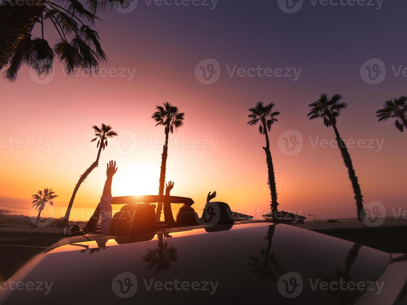 Happy young couple doing road trip in tropical city - Travel people having fun driving in trendy convertible car discovering new places - Relationship and youth vacation lifestyle concept photo