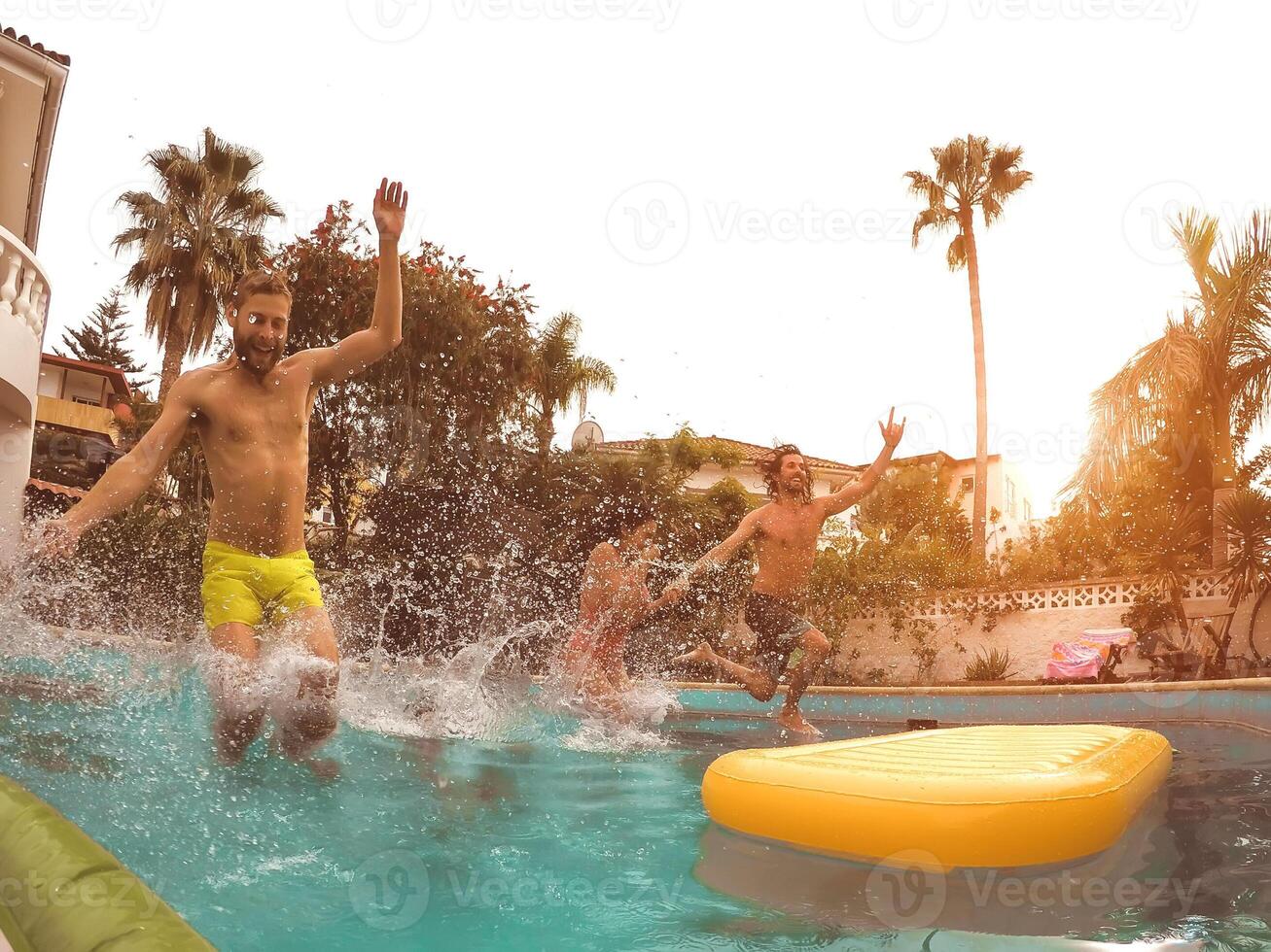 grupo contento amigos saltando en piscina a puesta de sol hora - loco joven personas teniendo divertido haciendo fiesta en exclusivo tropical casa - verano Días festivos vacaciones y juventud cultura estilo de vida concepto foto