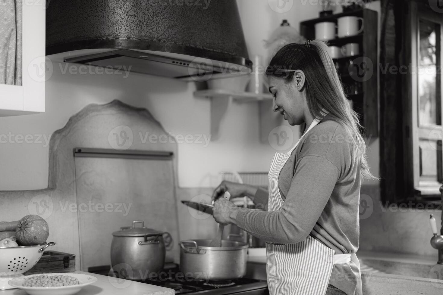 Latin woman preparing food recipe in her house - Black and white editing photo