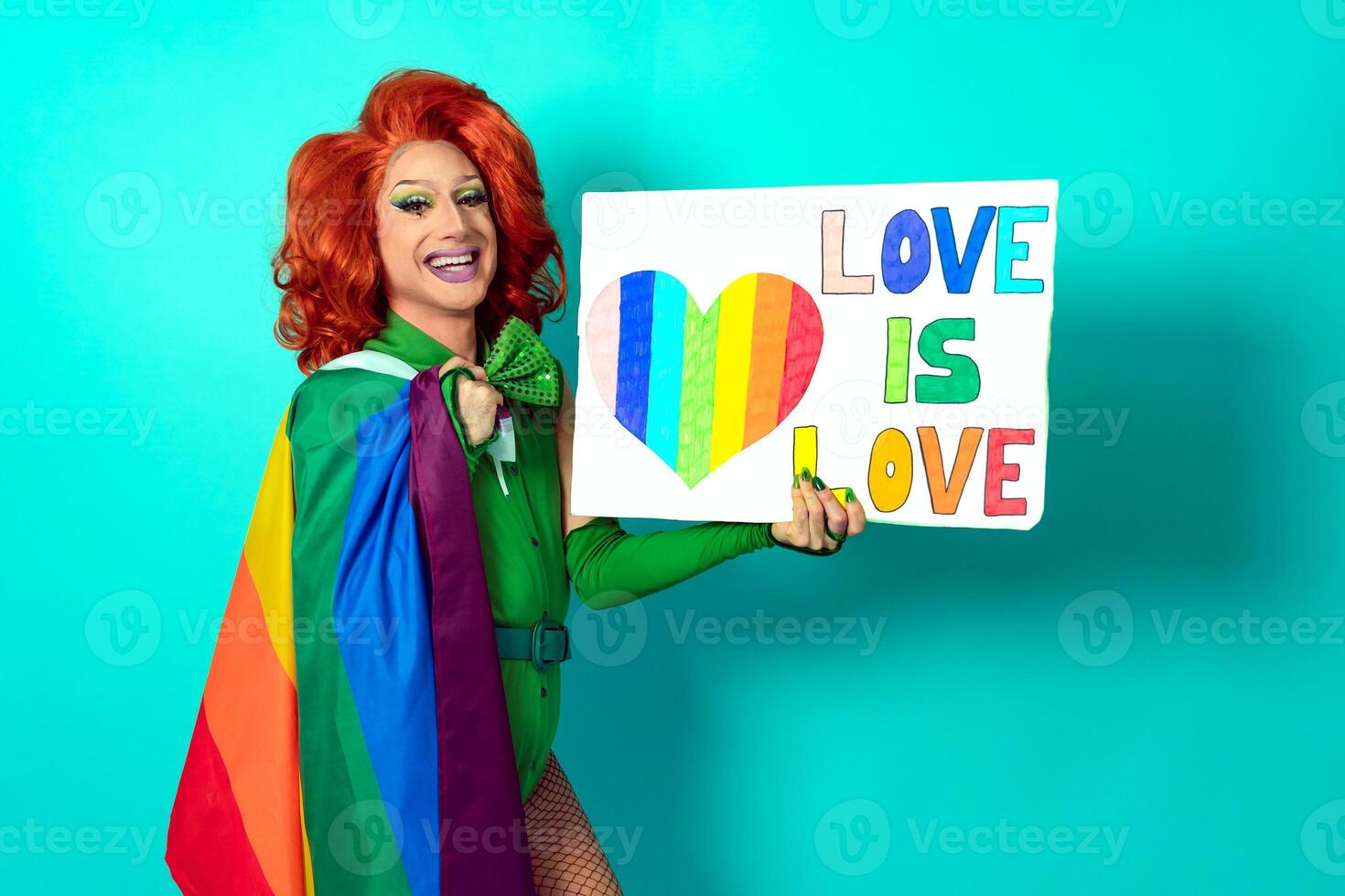 Happy drag queen celebrating gay pride holding banner with rainbow flag symbol of LGBTQ social movement photo