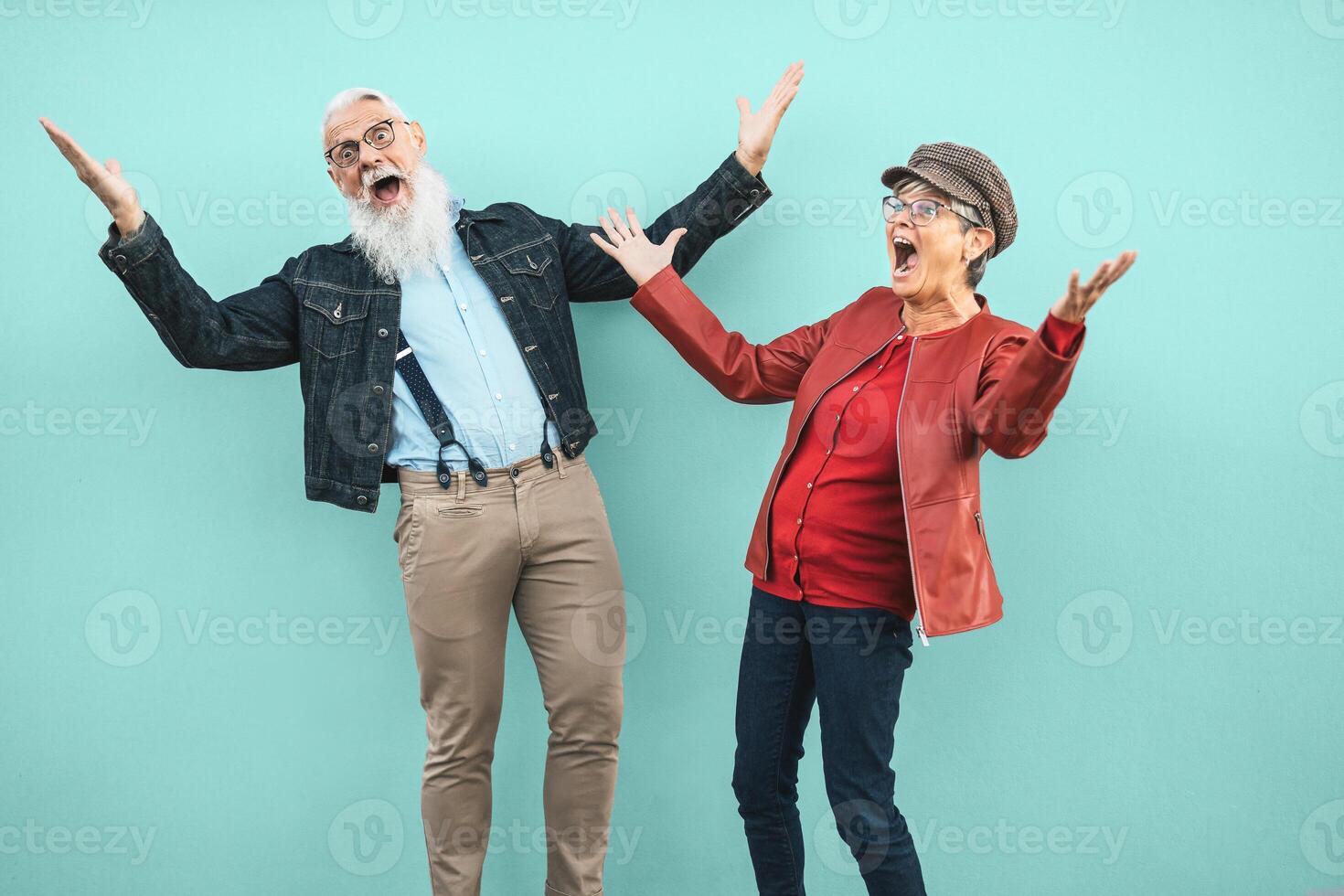 Happy senior couple having fun together outdoor - Retired man and woman celebrating crazy moments - Elderly people lifestyle and love relationship concept photo